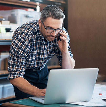 Man on phone while working on his laptop