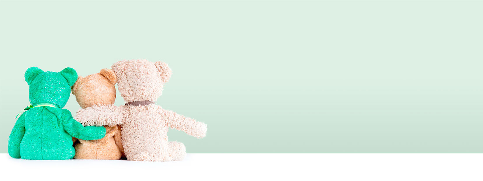 Three teddy bears hugging in front of a green background