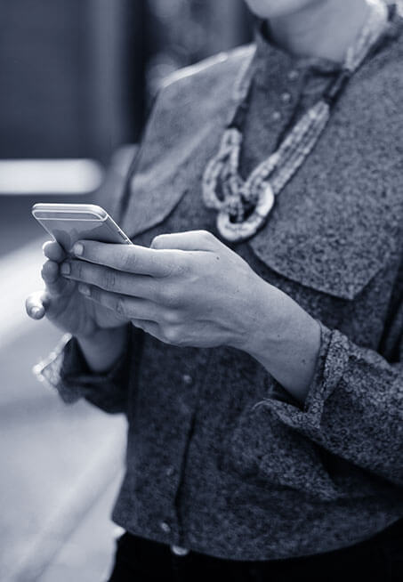 A black and white photo of a business women using her mobile phone
