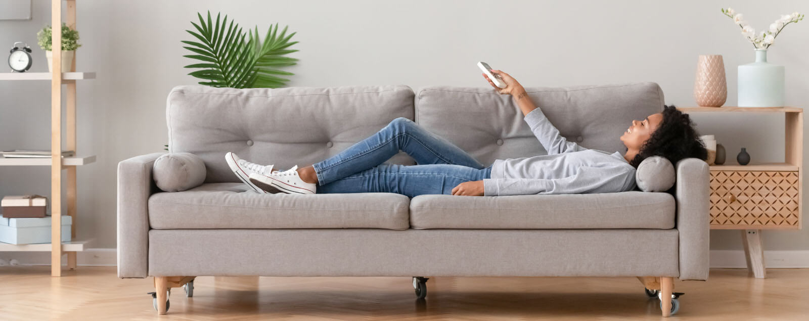 Lady laid on sofa with remote control