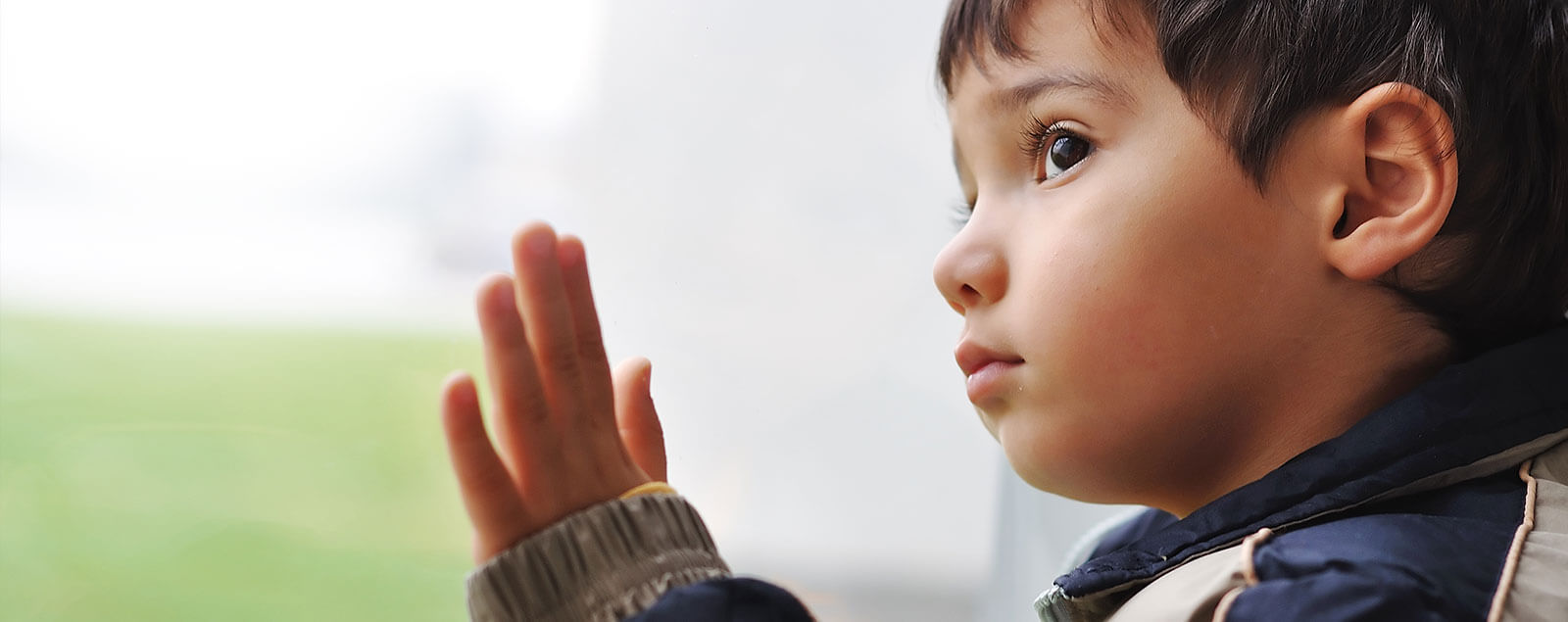 Worried child looking out of window