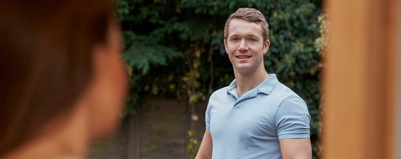 Man in polo looking at camera and smiling