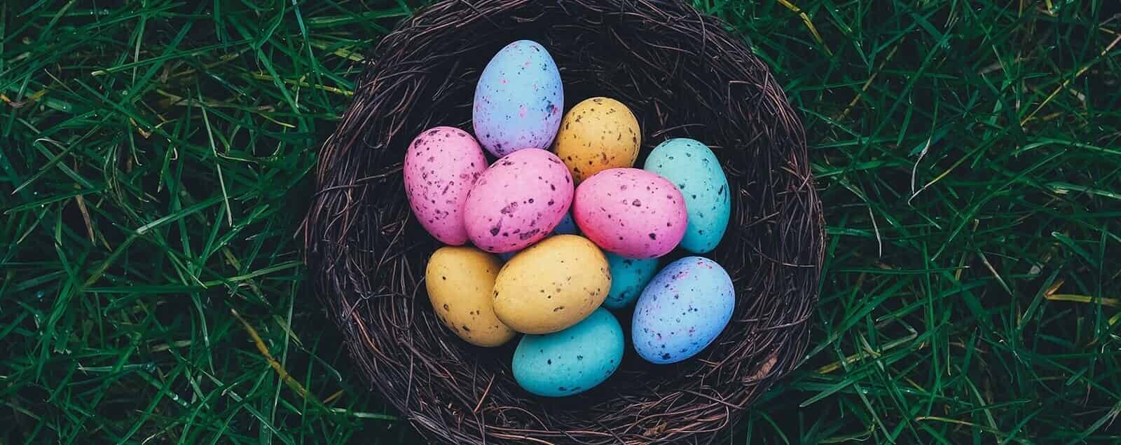 Multicoloured eggs in straw basket