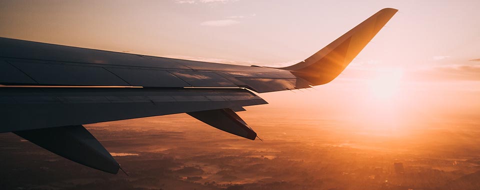 Aeroplane wing in front of sunset