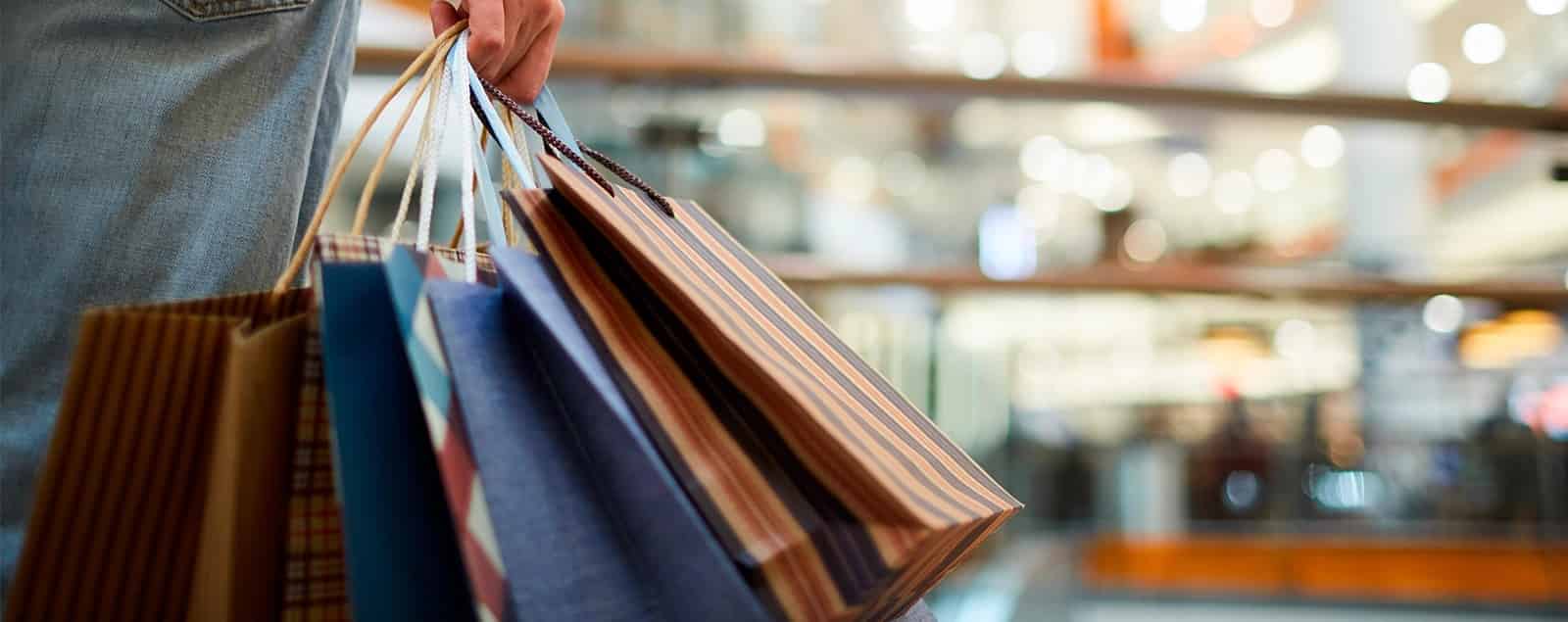 Hand holding multiple shopping bags