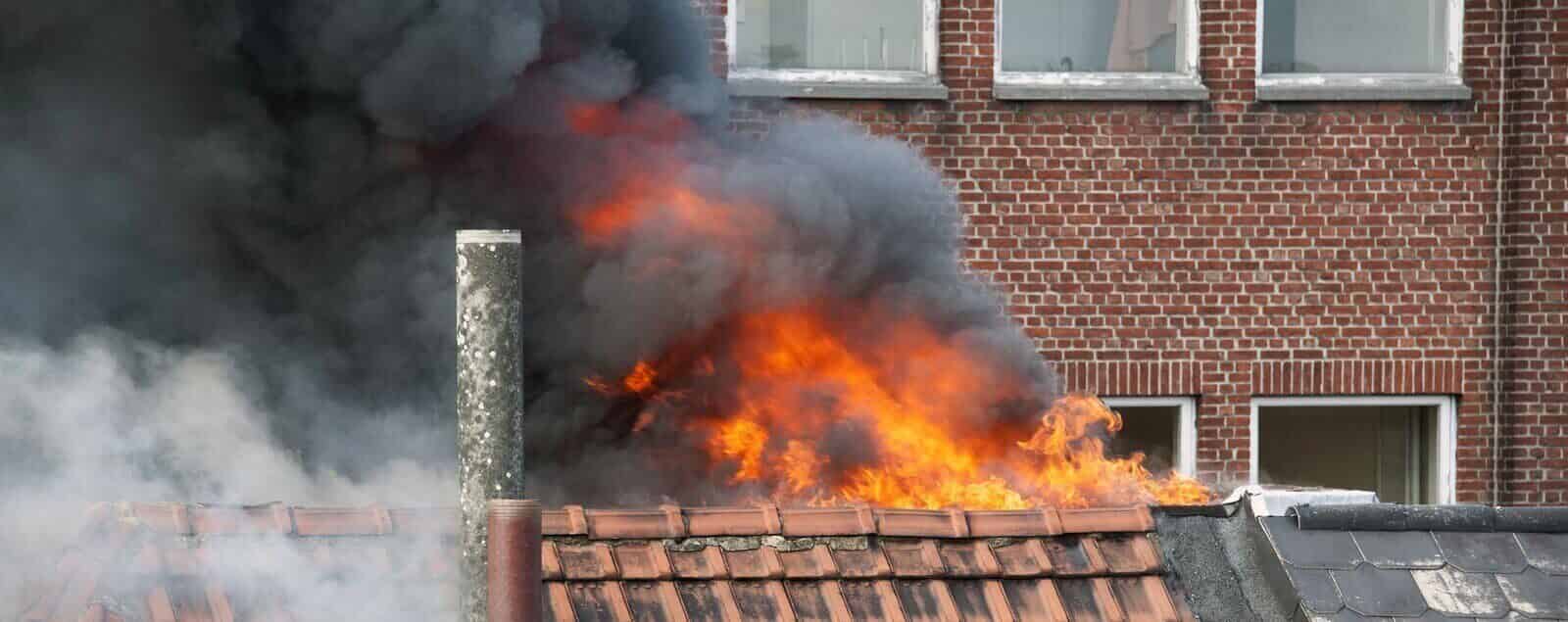 House roof with fire and smoke rising from it