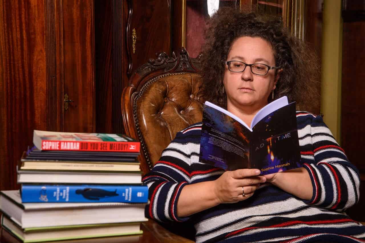 Lady reading next to a pile of books