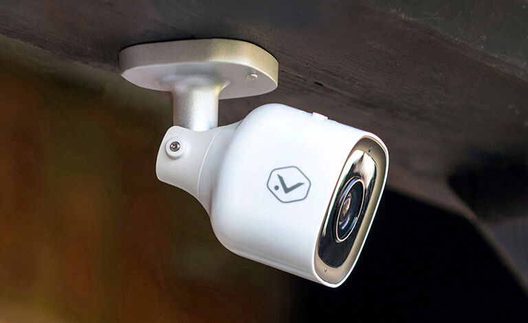 White security camera mounted on wooden beam