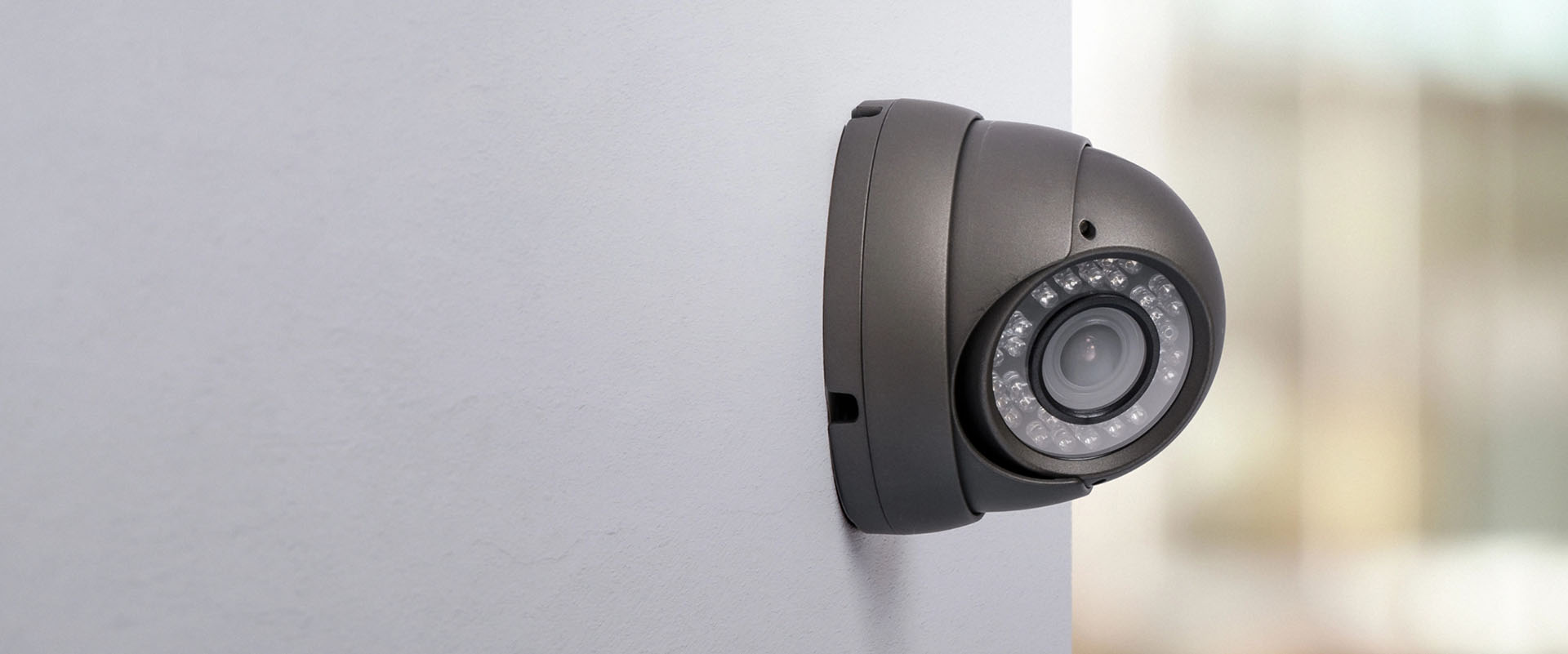 Black, wall-mounted security camera and light