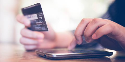 Hands close up of person making card payment on a smartphone 