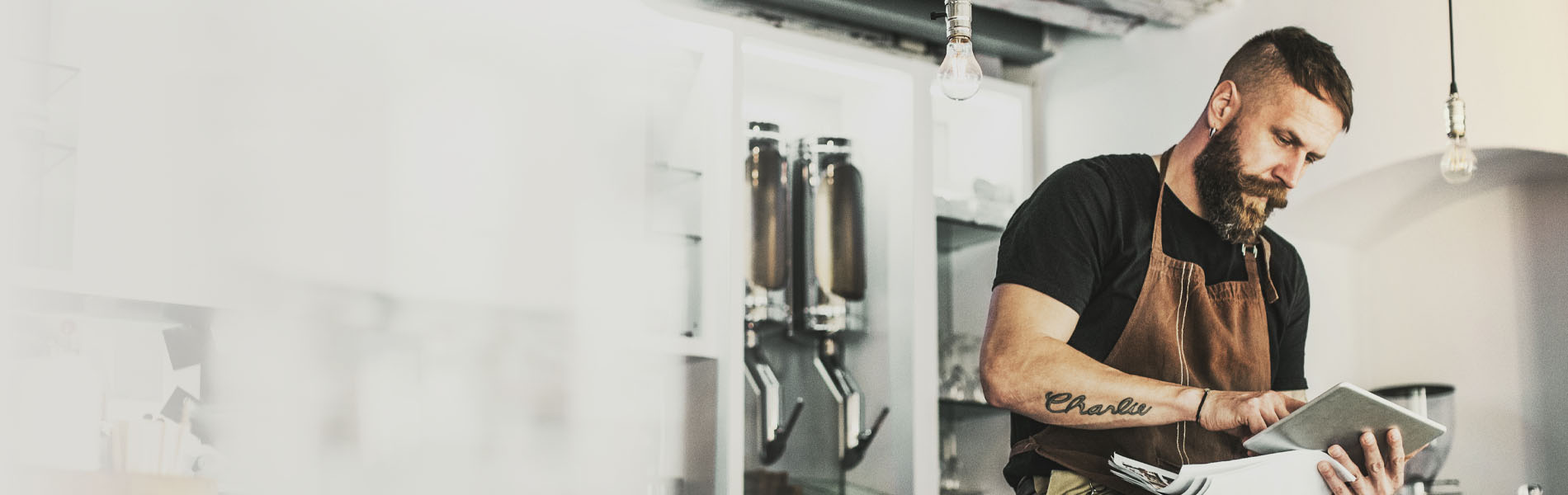 Man in apron using tablet