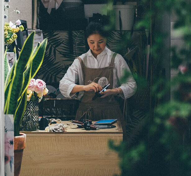 Lady fixing electronic equipment surrounded by plants