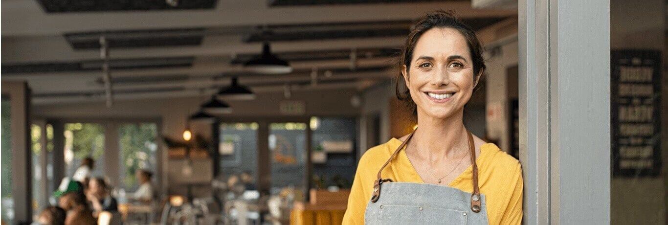 Café owner smiling at doorway