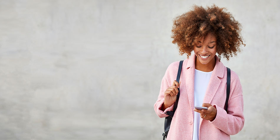 Lady smiling and looking down at the smartphone in her hand