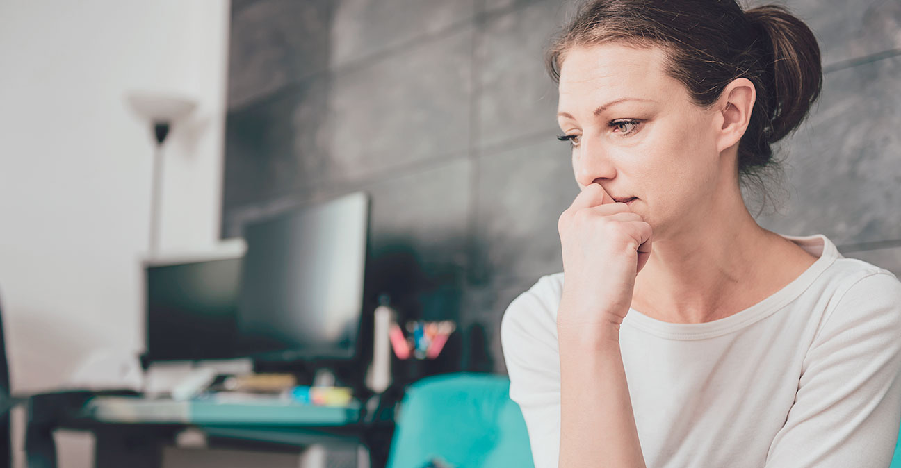 Lady with a worried expression with office space in background  