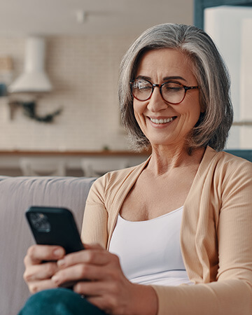 Lady sat on sofa looking at phone