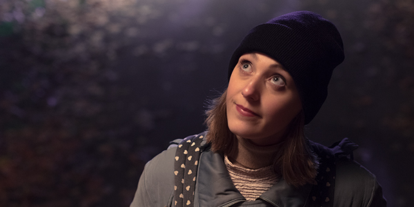 Lady wearing beanie outside at night looking up