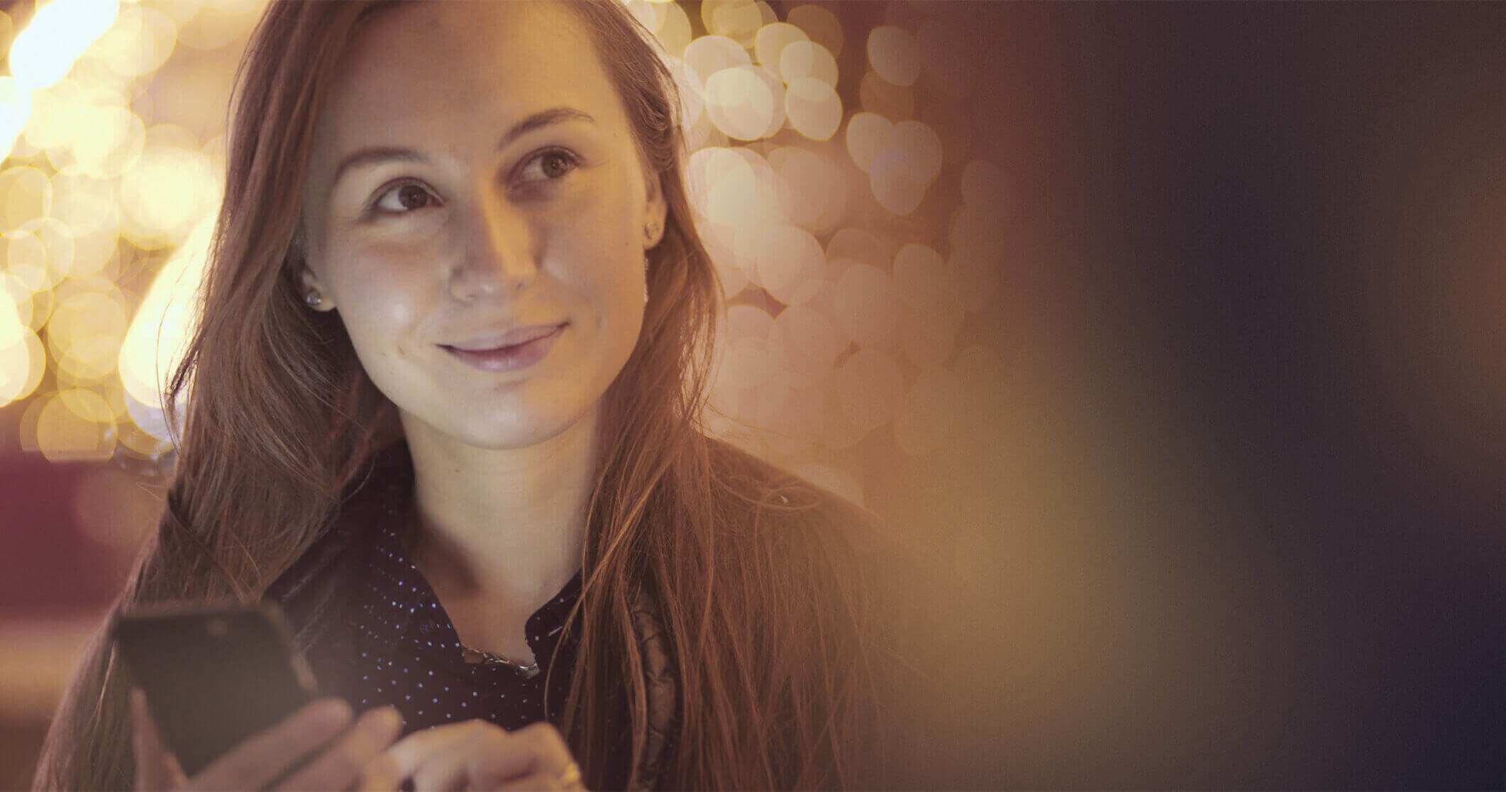 Smiling woman with phone in hands