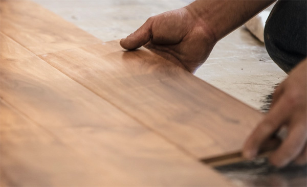 Hand shot of installing wooden flooring
