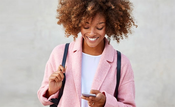 Lady smiling and looking down at the smartphone in her hand