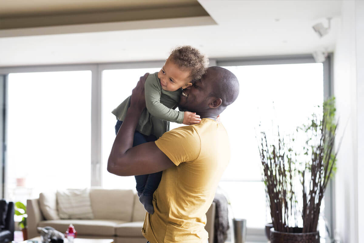 Man lifting up child and smiling