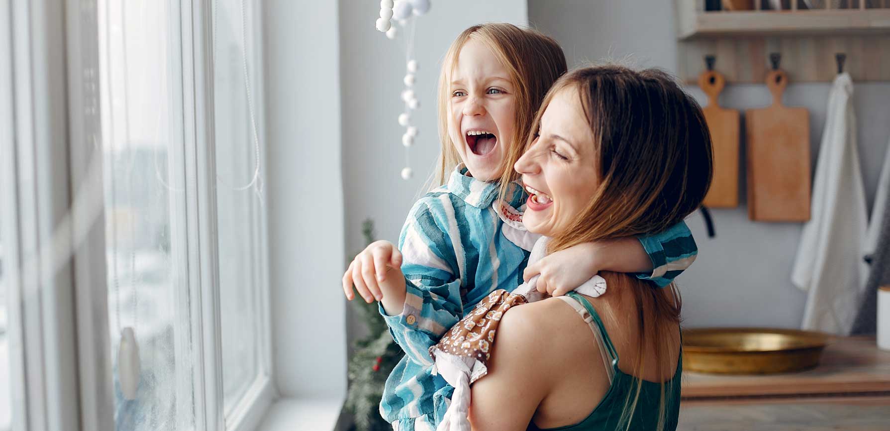 Mother holding daughter and laughing