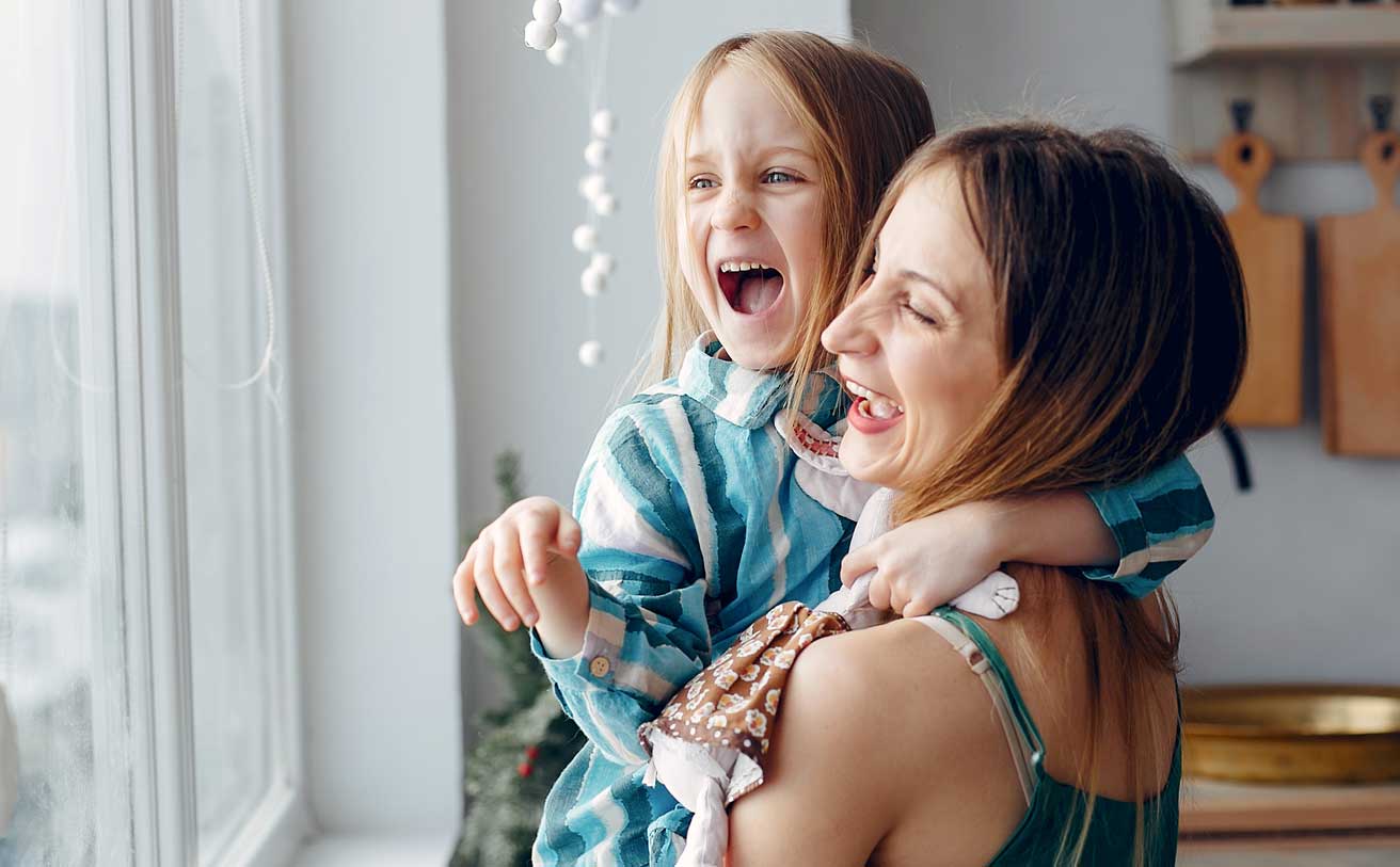 Mother holding daughter and laughing