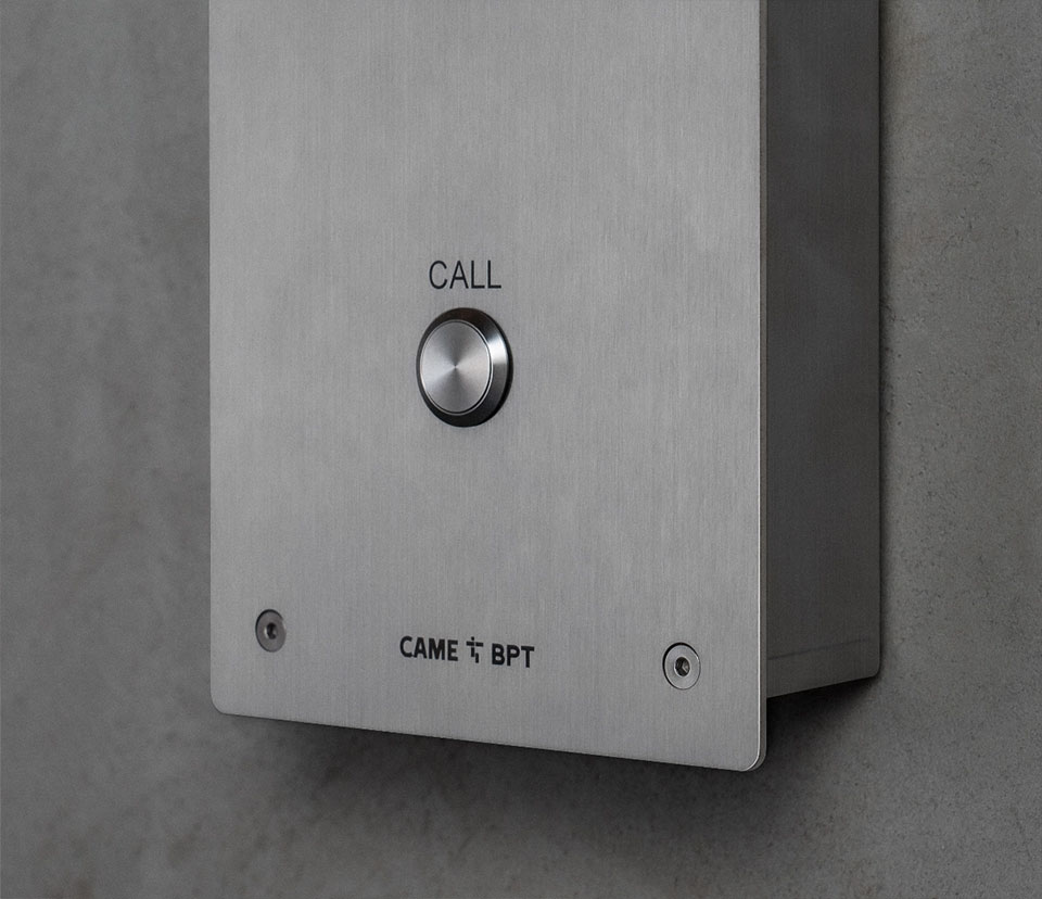 Metal, wall-mounted call button