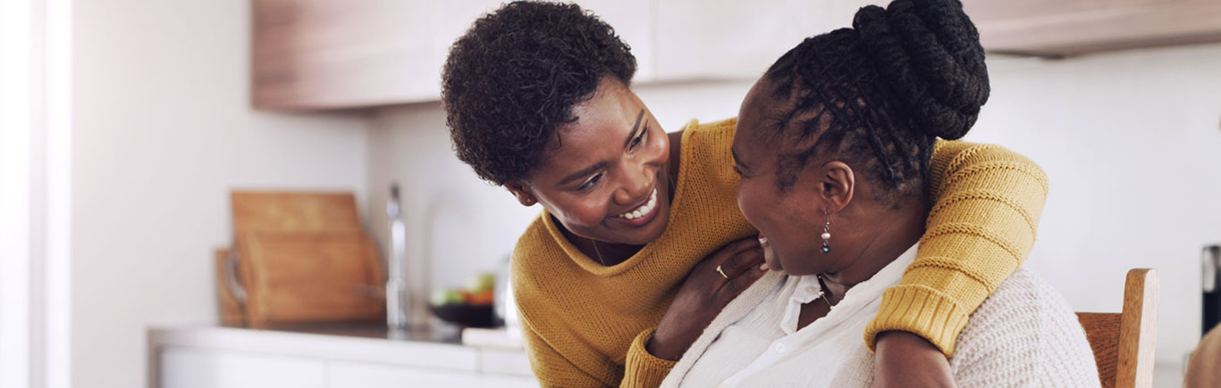 Two ladies hugging and smiling