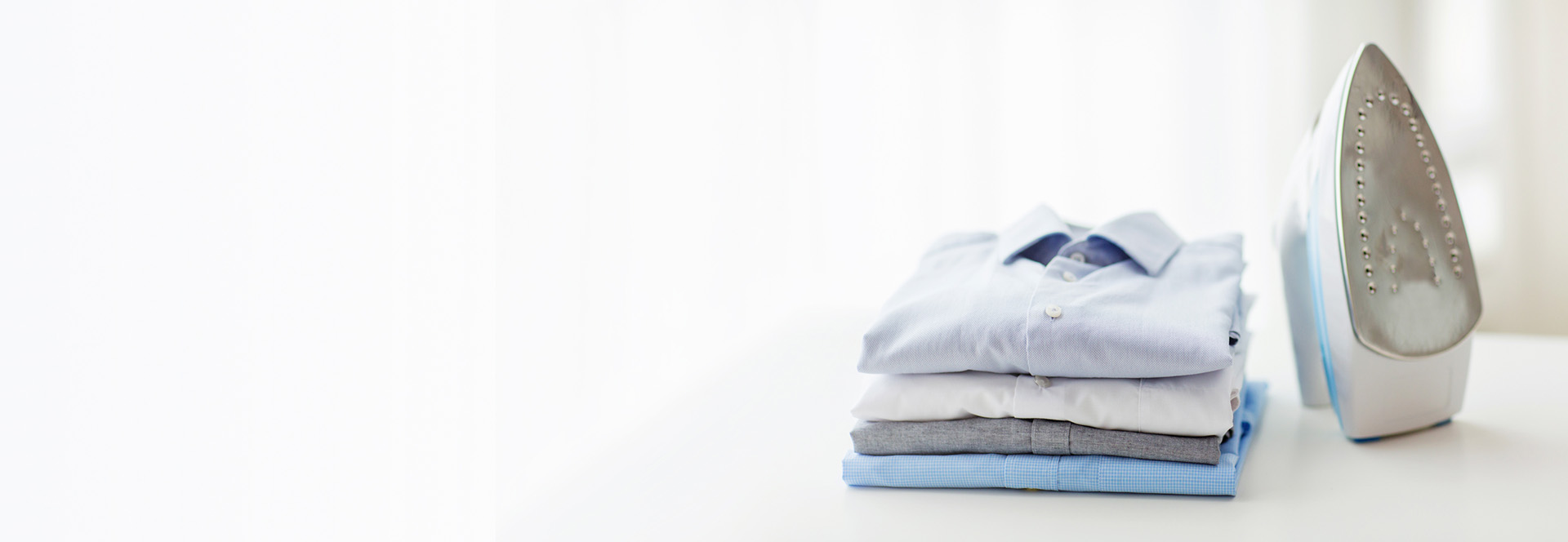 Folded shirts next to iron