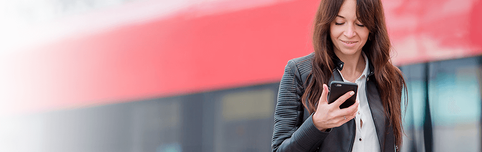 Lady looking at phone with train in background